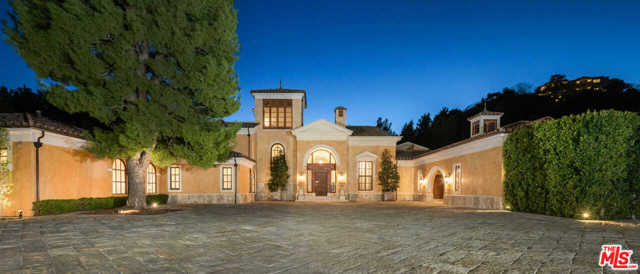 60 Beverly Parkway Beverly Hills, California Spacious and private, this gated Tuscan estate offers an unmatched lifestyle of leisure and elegance. Enter an expansive stone courtyard surrounded by manicured landscaping and a magnificent facade. Inside the 6-bedroom, 12-bathroom home, a sunken grand room has high coved ceilings, a stone fireplace, and two sets of arched French doors. A winding, travertine staircase connects the three levels. The kitchen includes wood cabinetry, stainless steel appliances, a marble island, and breakfast area. Lined with doors, a vast formal dining room curates a perfect entertaining space. Each bedroom including a palatial primary retreat offers its own views and impeccable design. Residents will enjoy an executive office, lounge area, large balcony, wine cellar, and theater with eight red velvet recliners. Outside, the 2.2 acres include a pool, gym, and tennis court.