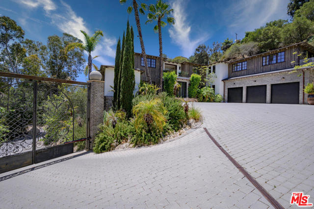 1105 Rivas Canyon Road Pacific Palisades, California This Pacific Palisades residence combines classic detailing and quality finishes with an open, contemporary floor plan that invites gatherings large and small. Extraordinary indoor and outdoor living spaces are set on approximately 1.9 acres of mature landscaping. Refined interior treatments include vintage tin and hand-coffered wood ceilings, floor-to-ceiling windows and disappearing doors, and premium limestone and hardwood flooring. There are two full kitchens, a humidor, grand bar, home office/library, and screening room. Four bedrooms on the upper floor include a luxurious master suite with lavish bath and private view deck. Verdant setting includes a 40-foot hanging garden, detached home office/guest house, 20-foot custom-made exterior dining table, and Island Stone pebbled pool and spa. 3-car garage and large motor court plus second driveway for parking/maintenance. A magnificent achievement in an irresistible setting.