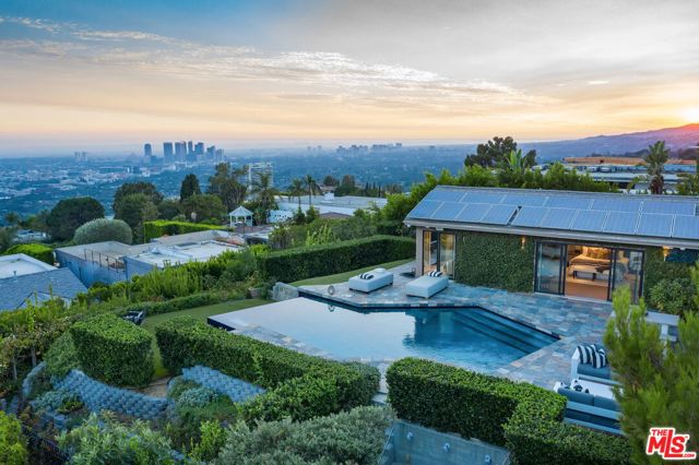 9000 Hopen Place Los Angeles, California Nestled on a small cul-de-sac off Blue Jay Way in the exclusive Bird Streets, this single-story jewel-box boasts unobstructed 180-degree jetliner views from Downtown LA to the Ocean. With an open floor plan, the living area is replete with vaulted ceilings and stunning herringbone-patterned wood floors. The recently remodeled chef's kitchen opens to the striking view with a massive center island with gorgeous marble waterfall countertops and built-in seating for 6. An impressive owner's suite opens out to the sleek infinity-edge pool, stone-tiled deck, and grassy yard with outdoor kitchen/BBQ. 2-car garage with additional private driveway spaces. With complete privacy, timeless architecture, and unparalleled views, this is a once-in-a-lifetime opportunity to own such a mesmerizing home on such a desirable parcel of land.
