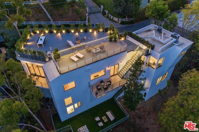 2376 Kimridge Road Beverly Hills, California Beautifully completely renovated contemporary with 14-foot ceilings and abundant natural light located on a quiet cut de sac in BHPO. Oversized open living/ dining room combination provides walls of glass that overlook explosive canyon views. Grand cook's kitchen with top of the line appliances showcases gorgeous slab marble island. This functional floor plan provides 2 master suite options; Lower level features master and 2 additional bedrooms & upper-level showcase a beautiful junior master suite with walk-in closet & spacious bath. Large 2,000 sf rooftop deck provides incredible entertaining options with 180 Canyon views. Oversized turfed deck built off the back of the house provides private backyard perfect for entertaining.