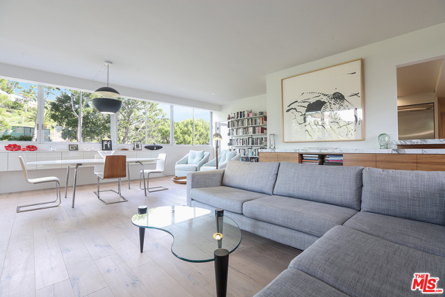 17352 W Sunset Boulevard 301 Pacific Palisades, California Exquisite 2 bedroom, 2 bathroom condominium at the full service Edgewater Towers perched hillside just 100-yards from the Pacific Ocean. This units minimalist design is polished by modern architectural finishes that complement its mid-century roots. Picture windows span opposing walls for natural light and ocean cross breezes to flow, treetop views, and glimpses of the ocean. An open floor plan allows for effortless movement and features hardwood floors throughout, a white marble slab fireplace with black slate hearth in the living room, and a sleek, modern kitchen anchoring the entire space. Rich wood lower cabinets are balanced by the white high gloss uppers, stainless steel appliances, and floor to ceiling white marble slab countertops and backsplash. Primary bedroom has built-in shelving, walk-in closet, and ensuite bath with slate flooring and glass enclosed double shower and soaking tub. The den/office is designed with custom built-in cabinetry and desk space, but easily becomes a second bedroom with closet and ensuite bathroom. Sip coffee on your private balcony, or enjoy the Edgewater Towers amenities such as basketball and tennis courts, fitness center, heated pool and spa, and 24-hour security. Close to hiking trails, shopping, Will Rogers State Beach, and a quick drive down PCH to Santa Monica or up to Malibu.