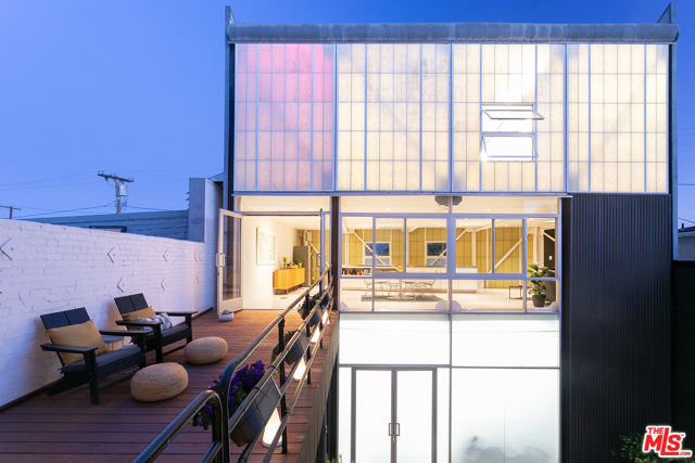 308 Venice Way Venice, California Designed and built by award-winning architect, artist, filmmaker, and educator David Ming-Li Lowe, this rare Artist-In-Residence compound, 3 blocks from the beach, has been completely renovated and outfitted with high-end fixtures and finishes, including a Boffi kitchen, providing an attractive integrated experience for the creative entrepreneur. As Gebhard and Winter noted in their classic Architectural Guidebook, you could easily drive by and not notice this building, but once it catches your eye, an exquisite attention to detail is readily apparent. The loft-like live/work space is defined by two mirrored 3-story buildings that secure the perimeter, sheltering a private inner courtyard that connects the two domains. From the front, a commercial storefront signals business activities within, while direct entry to the 3-car garage/workshop from the alley provides ample security. The two towers above hold separate Master Suites, with living room and kitchen on the middle level, connected by a hardwood deck suspended above the courtyard. The overall composition is a celebration of structural steel, inspired by predecessors like Craig Ellwood and Pierre Koenig, with exposed posts and beams, elegant cross bracing, and high-performance, energy-efficient, translucent Kalwall building panels interspersed with clear French doors and operable windows.