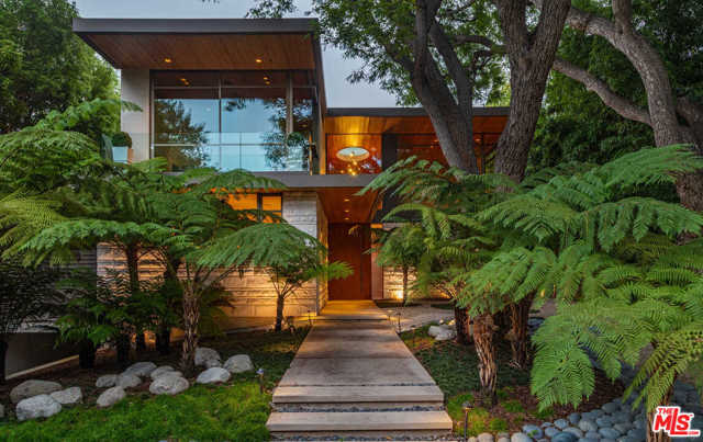 456 N Carmelina Avenue Los Angeles, California Impeccable William Hefner designed custom Contemporary in the heart of Brentwood. Ideally located on the rim side of highly desired N Carmelina. Completely privatized from the street, this property is surrounded by lush green landscape and mature trees throughout. Upon entering the gates, one is transported to a serene and lush resort like retreat. Inside offers true open concept living, blending the indoors and outdoors mixed with trees, views and nature to create a zen feeling throughout. The main level opens up to an entertainers backyard with an infinity edge pool, 2 covered patios both with fireplaces, a built in BBQ and a sports court. Upstairs the master suite is a retreat in it's own with a Tree house like master office, master bed that looks onto canyon/Getty Center views, and a master bath with unparalleled design. The lower level contains a 6-8 car 2,000 + sqft garage with workspace, a large entertainment room with bar, media,game area,gym, large laundry plus a prep kitchen.