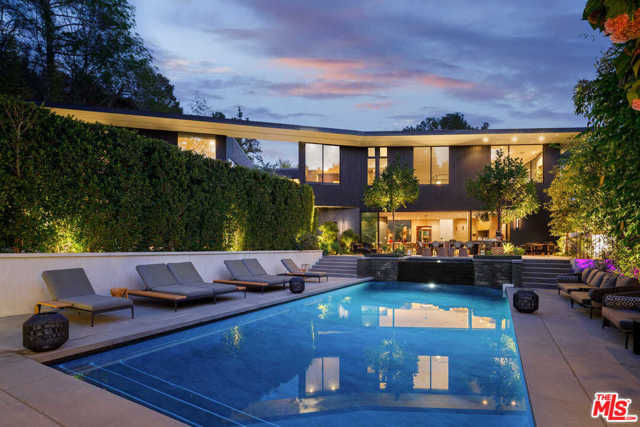 7631 Willow Glen Road Los Angeles, California Bringing Aspen to LA. Welcome to a contemporary, zen-inspired architectural gem built by world-renowned architect interiors firm, Masastudio. Located on a quiet, gated cul-de-sac, the home is surrounded by trees, mature landscaping and sits on a lush acre in the Hollywood Hills. The peaceful main courtyard, surrounded by an expansive, multi-level living space. Skylights and soaring ceilings create sun-soaked rooms. The kitchen features stainless steel Miele appliances, stone countertops, floor-to-ceiling cabinetry, an island, and doors that open up to the pool pavilion. Find an outdoor kitchen, a waterfall, resort-style pool, pizza oven, and winding paths. The primary suite offers a large, glass-enclosed stone shower, surrounded by a walk-through closet. The 6 ensuite bedrooms present unique styles and details such stone accents and built-ins. A lower level includes a recording space, theater, bar, and gym. Enjoy the convenience of a 3-car garage and Hollywood shopping and restaurants.