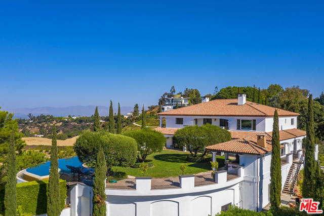 2576 Bowmont Drive Beverly Hills, California Set behind the private gates of Bowmont Estates rests a timeless Mediterranean compound perched atop its own promontory with extraordinary views from the ocean to the canyon. Enter through the grand two-story foyer to the large public rooms, framed in double French doors. The main level features a chefs kitchen, dining room, living room, office and en-suite bedroom with Infrared sauna. Upstairs includes the master suite with two bathrooms, steam showers, dual massive walk-in closets and a sweeping balcony that captures the picturesque sunsets. Additionally, two spacious en-suite bedrooms. The guesthouse features an en-suite bedroom, kitchenette with living room and gym. Adjacent, an entertainment wing with a home theatre, and a bar that flows into a wine tasting room idyllic for entertainment. The grounds include vast terraces, an outdoor kitchen and dining pavilion, a lush grass lawn and a wraparound infinity pool and spa floating above its surroundings. Truly a unique setting.