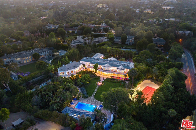 Nestled on nearly three rolling acres in the heart of Holmby Hills is Paul Williams largest original creation. With interiors of the grandest scale, The Azria Estate beams sophistication, timeless design, and an esteemed Los Angeles heritage. The 17 bed, 25 bath reimagined 1930s home proves to be an unwavering rarity across the globe to this day. From the floor-to-ceiling Swarovski chandelier in the grand dual staircase foyer to the shimmering metallic leaf draping from the living room ceiling, the elevated design-centric elements are in idyllic contrast to Williams quintessential colonial architecture. Sixty rooms in total, each with intricate trim work, voluminous window treatments, and bespoke finishes for a lavish sense of sophistication throughout. Amenities are complete with a separate 6000 SqFt structure that includes a grand theater and a gold ceiling dome library overlooking the manicured grounds. The terraced exterior and tranquil waterfalls lead to a glass-walled tennis court perched aside the Moroccan bathhouse and an inviting authentic hammam, all complementing the intricately blue tiled swimming pool. Cultural integrity completes the grounds with a Japanese Garden and teahouse, French Courtyard, and a romantic greenhouse. As a Paul Williams revival, The Azria Estate is truly a legacy property in prime Holmby Hills.