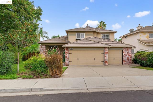 Traditional home with brick siding, an attached garage, concrete driveway, and a tile roof