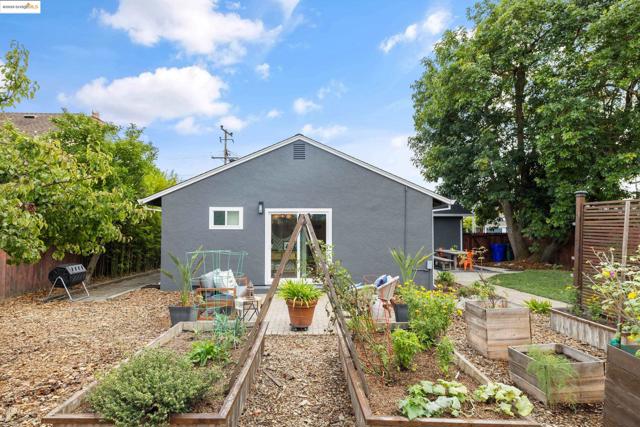 Back of house with a patio, stucco siding, and a vegetable garden