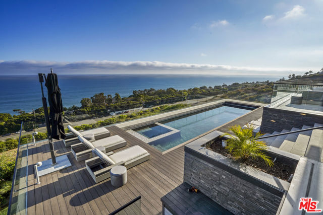 Introducing "Seaside Serenity," a remarkable property spread across nearly 13 acres above the Pacific Ocean in the prestigious enclave of Malibu. This exceptional estate presents an extraordinary opportunity, comprising two parcels of coastal splendor. The first parcel features the existing, newer construction home, while the second parcel comes with meticulously crafted plans designed by the renowned architect Doug Burdge. Upon entering, you'll be captivated by the seamless integration of indoor and outdoor spaces, designed to maximize the breathtaking ocean and coastline views. Sunsets here are nothing short of spectacular. The residence itself is a masterpiece of contemporary architecture, featuring high-end finishes and an open-concept layout that encourages a relaxed coastal lifestyle. With spacious living areas, a gourmet kitchen, and expansive windows, every room offers an exceptional vantage point to appreciate the natural beauty of the Pacific. Inside, indulge in a wealth of amenities, including a seaside lounge for quiet contemplation, a well-equipped gym for fitness enthusiasts, a dedicated office for productivity, and an impressive 800-bottle wine cellar complete with a wine-tasting bar. Enjoy movie nights in the deluxe home theater, and offer guests a lavish retreat in the guest suite. The crown jewel of this residence is the 1300-square-foot luxury master retreat, providing a private oasis of comfort and tranquility. Crestron Smart Home Technology, security cameras, and an elevator enhance the modern convenience, while the motor court and 4-car garage provide ample parking. With two parcels, one boasting an existing luxurious home and the other featuring visionary plans by Doug Burdge, Seaside Serenity is more than just a residence; it's a canvas of endless possibilities for those seeking the epitome of Malibu coastal living.