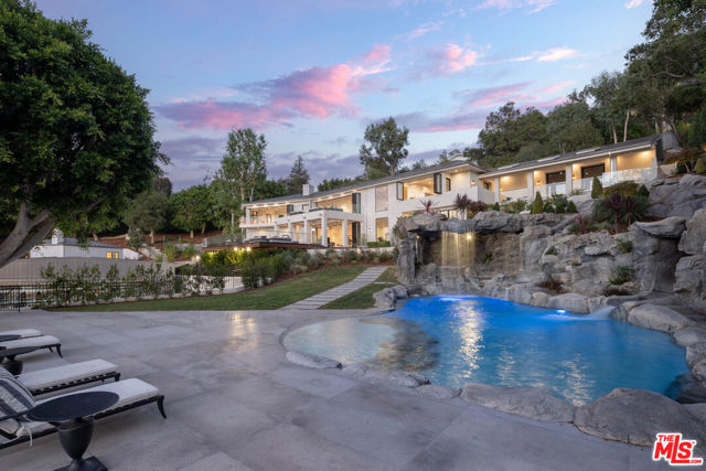 9694 Oak Pass Road Beverly Hills, California The ultimate in luxury, privacy, and scale is on display at this completely remodeled, gated Beverly Hills compound featuring over 13K square feet of living space, 1K feet of decks for the entertainer, and sprawling over 1.7 acres of land. If you think you know this house, think again. This iconic home has been completely re-imagined to become the epitome of luxurious California indoor-outdoor living. Nestled in the exclusive privately gated community, Oak Pass Road, this home has been designed for the discerning buyer who wants it all. The property offers a large main house, separate two-story guest house, private, stand-alone two-story gym with a professional boxing ring, full-court basketball court, resort style pool with grotto, waterfalls, and a waterslide. Full outdoor kitchen with wood-burning pizza oven makes for the perfect outdoor gathering space with sweeping canyon and sunset views. Enjoy your favorite movies in the fully equipped and huge theater with 136" screen, wet bar and wood burning fireplace. This home includes a motor court, 3 car garage, putting green and so much more you have to see to believe at this remodeled masterpiece. The main house features 5 bedrooms and 6 bathrooms showcasing natural light, walls of glass and full smart home automation by Savant. The brand new chef's kitchen has Wolf and SubZero appliances, beautiful counter tops and stone by Walker Zanger, climate-controlled wine storage and huge, bi-fold windows for indoor-outdoor living. Multiple living areas offer opening walls of glass, views, high ceilings, white oak wire brushed wood floors and beautiful finishes throughout. Family and friends can relax in the 2 bedroom, 3 bathroom guest house with it's own full kitchen and private patios. The home also offers a hair salon, private staff entrances, manicured grounds and citrus trees, multiple fire pits and water features. Come and experience this one-of-kind showpiece today.