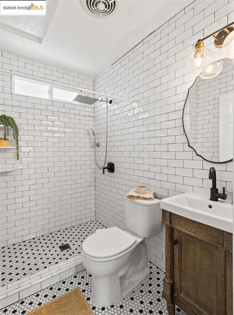 Bathroom featuring tile walls, vanity, a stall shower, and tile patterned floors