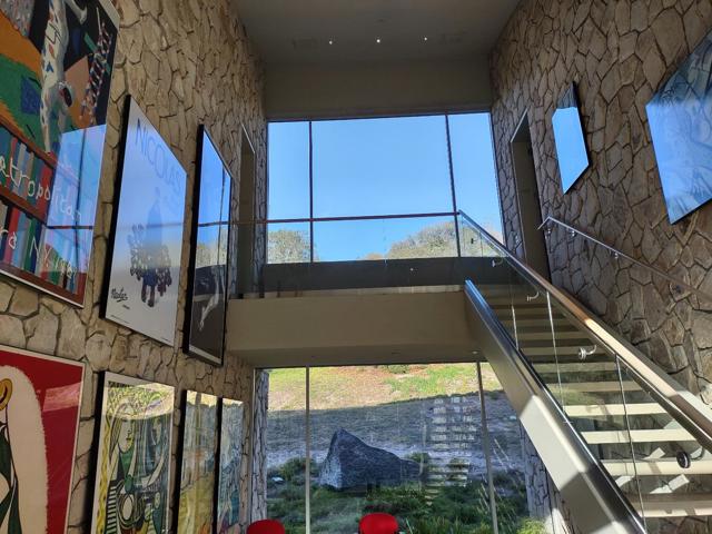 TWO STORY MAIN LOBBY WITH FRAMED ART ON STONE WALLS