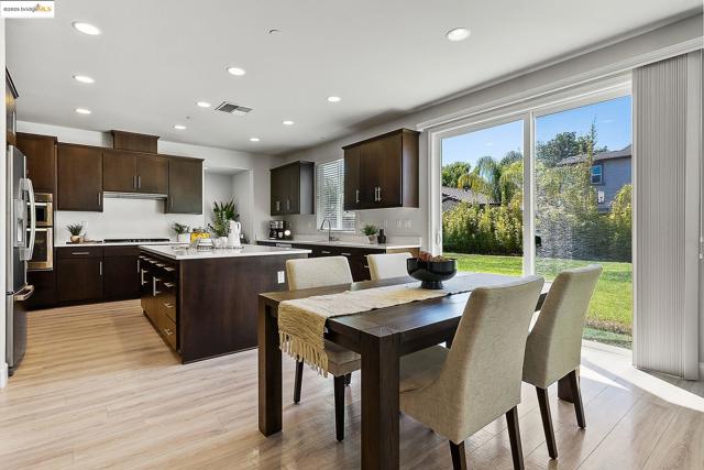 Kitchen featuring a center island, dark brown cabinets, recessed lighting, light countertops, and light wood-type flooring