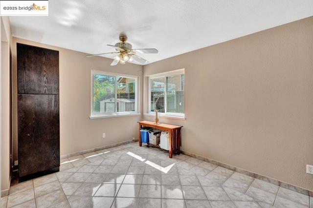 Unfurnished bedroom featuring light tile patterned flooring and ceiling fan