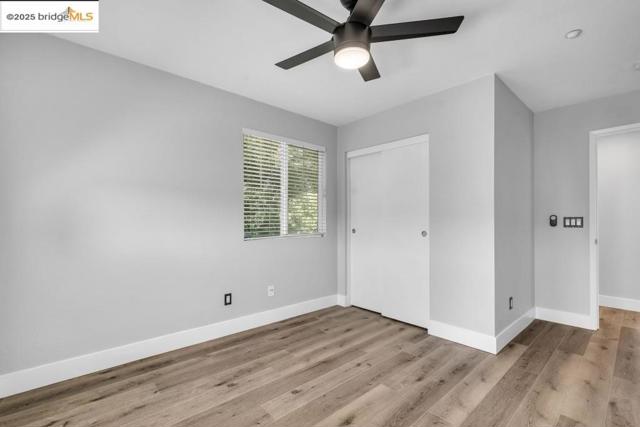 Unfurnished bedroom with light wood finished floors, a closet, and a ceiling fan