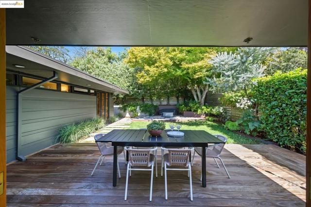 Wooden terrace with a fenced backyard and outdoor dining area
