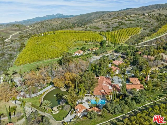 Immerse yourself in the rare luxury of this Tuscan-style villa near historic San Juan Capistrano. This magical 1200-acre estate offers sweeping views of foothills and mountains, creating an idyllic retreat. Formerly owned by celebrities like Bruce Brown and Dick Marconi, this property exudes California luxury, embraced by nature's beauty and enriched by the storied ownership of iconic personalities.The compound, surrounded by lush greenery, features over 23,000 lemon and 1,200 olive trees. Imported bare root from Italy, these olive trees belong to a 3000-year-old strain, adding a touch of ancient elegance to the landscape. Enhancing the sense of tranquility, a private 2-acre lake and four ponds grace the landscape. Exquisite stonework, with each stone quarried from the property, effortlessly blends with the botanical beauty. The entrance courtyard features a bronze statue of a wild boar "Porcellino" from Florence. At the edge of the pool stands a 15 ft statue of Poseidon, while multiple bronze and marble statues, along with a full-size terracotta Chinese warrior statue, contribute to the opulence of this extraordinary place.The main residence offers over 5,000 sq ft of living space, including 4 bedrooms and 3 bathrooms. The loggia overlooking the lake creates a serene atmosphere. The rustic kitchen, equipped with a Viking range and an oversized Sub-Zero fridge, combines functionality with style. The primary suite features floor-to-ceiling windows, a fireplace, walk-in closets, and a spa-like bath with a step-up tub and a large shower. The second master, guest bedrooms, and den seamlessly blend into the character of the house.A special ventilation system ensures a perfect environment in the wine and cigar lounge, with a 3,000-bottle temperature-controlled wine storage room for connoisseurs to savor the finest selections. The private chapel holds a replica of Michelangelo's "La Pieta," in the 2,000 sq ft office/library and museum. Natural light floods into the north-facing floor-to-ceiling windows of the art studio, offering over 2,000 sq ft of space dedicated to creativity. Complete with a bathroom and storage area, this studio is a haven for artistic expression. Adjacent, an equally large art gallery features museum-quality lighting, showcasing artwork in its finest form.Exceptional amenities like a helicopter pad, short and long-distance gun range, a two-bedroom guest house, and a fully equipped fitness center add a unique dimension to the property. While stargazers explore the skies from the observatory, the wine gazebo offers a tranquil setting to savor exquisite vintages. The 12-car garage provides 2,200 sq ft of space for prized automotive collections. A well-equipped over 2,000 sq ft workshop caters to hobbyists and craftsmen alike. The employee triplex ensures 2,100 sq ft of living quarters for the staff.Thoughtfully designed to harmonize with nature, a 70-acre wildlife sanctuary provides a haven for diverse species such as llamas, eland, zebras, and a giraffe. Equestrian grounds feature a 6-stall barn, a horse riding arena, and a network of trails that wind throughout the expansive ranch, providing a picturesque setting for horseback adventures. Spacious dog kennels and an aviary add to the diversity of animal life on the property. Lakes and ponds throughout the estate may be stocked according to preference.Embrace unparalleled peace and tranquility within this private oasis. This extraordinary estate, surrounded by nature's beauty and thoughtfully designed amenities, offers a retreat from the outside world. Whether savoring the exquisite architectural details or immersing yourself in the diverse animal habitats, every element has been curated to provide a sense of serenity. The allure of California luxury is palpable with panoramic views extending all the way from Mexico to the Channel Islands. Experience the epitome of refined living, where each day is a celebration of life in the embrace of Mother Nature.