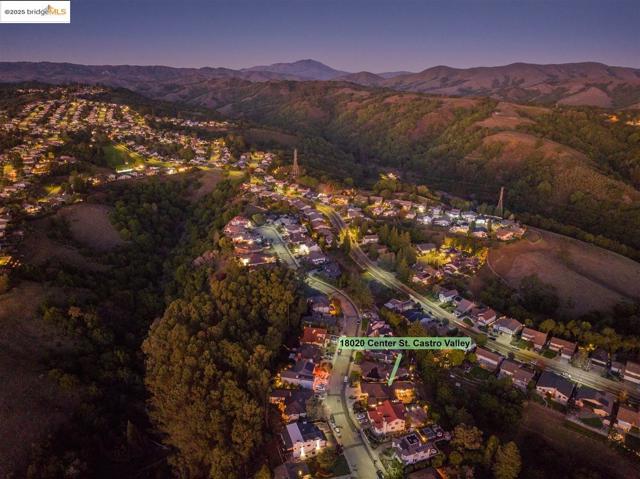 Aerial view of property's location with nearby suburban area and a mountain backdrop