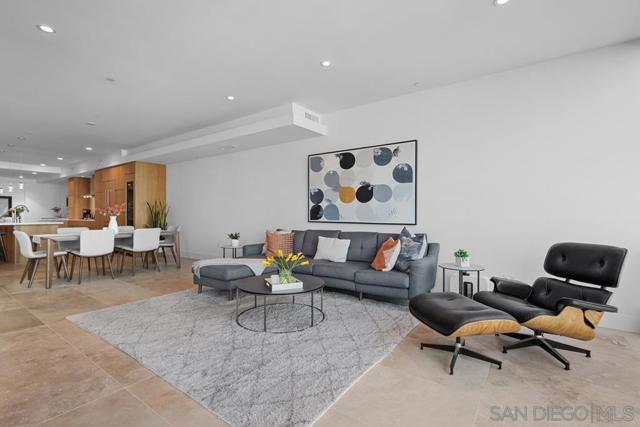 Living room featuring an open floor plan with imported Turkish stone tile flooring and access to a spacious private patio with cityscape views.