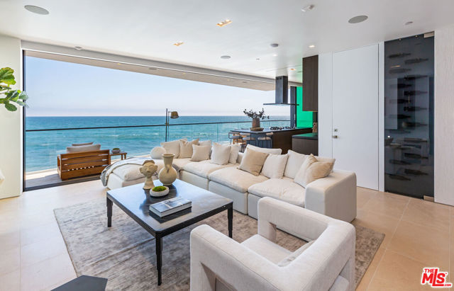 This new construction home is a fully customized smart home, boasting panoramic ocean views, 57 ft of beach frontage and a custom-crafted contemporary design. The elegant beachfront property is close to Santa Monica and minutes to the Malibu Country Mart. The home was made with a steel frame to allow for a complete open floor plan with no obstructions of ocean views. The great room and kitchen hang over the Pacific Ocean, with automated Fleetwood doors that open on either side, to create an indoor/outdoor living space. The kitchen features all top of the line Miele appliances, soft close fridge, stone top burners and automatic shades throughout the home. All three ensuite bedrooms feature wide plank walnut flooring, custom closets with Italian leather shelves and natural limestone bathrooms. The grand primary suite features tall ceilings and a spa-like bath with soaking tub and opens to the outdoor oceanfront deck. On the rooftop deck, you'll find a modern imported hot tub, fire pit and all custom marine grade appliances for BBQing in style.
