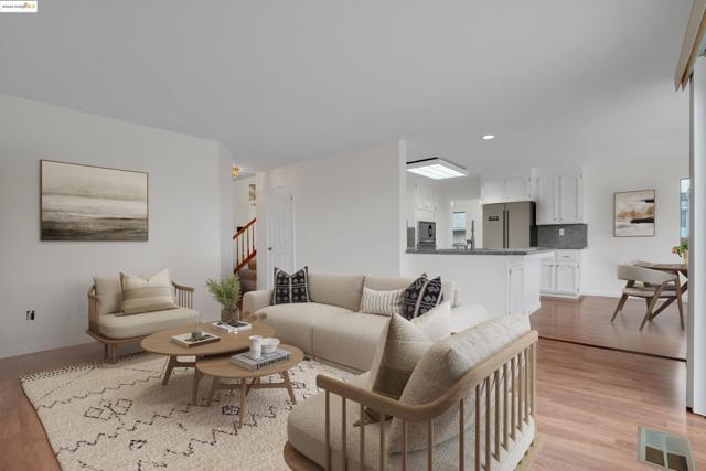 Living room with light wood finished floors and recessed lighting