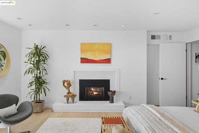 Bedroom with recessed lighting, wood finished floors, and a brick fireplace