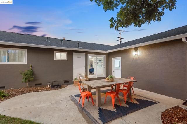 Back of property with crawl space, a patio, stucco siding, outdoor dining space, and roof with shingles