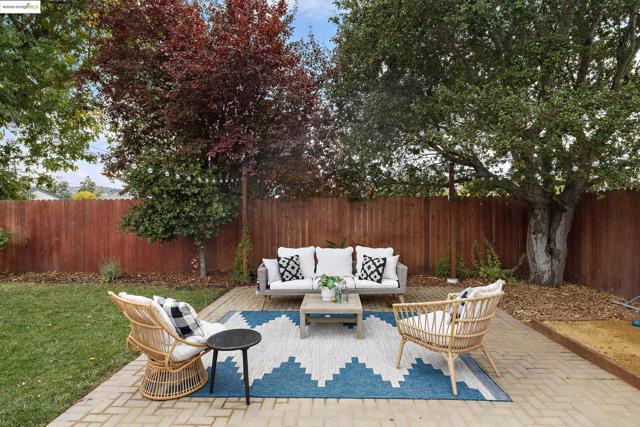 Fenced backyard featuring an outdoor hangout area and a patio
