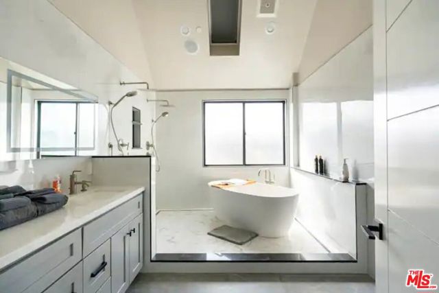 Bedroom #5 en suite bathroom with a his and hers vanity, high ceilings, and double shower area.