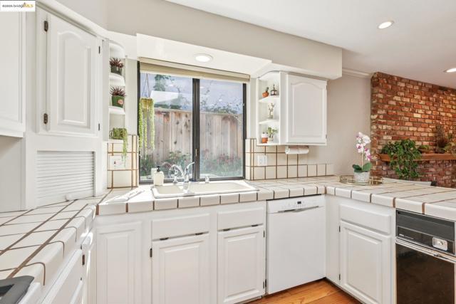Kitchen featuring open shelves, white dishwasher, tile countertops, white cabinets, and recessed lighting