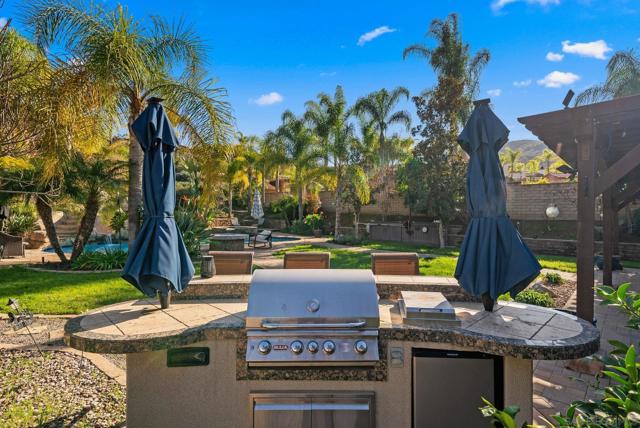 outdoor bbq island onlooking backyard and pool