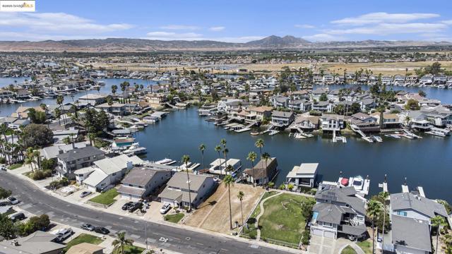 Aerial view of property and surrounding area with nearby suburban area and a water and mountain view