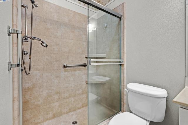 Tile floors and custom shower surround complete with seat and grab bars.