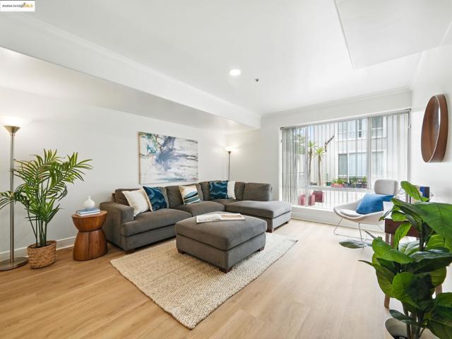 Living room featuring light wood-type flooring, ornamental molding, and recessed lighting