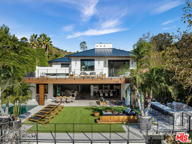 Nestled in the treetops above Beverly Hills, A totally Bespoke Estate, Spanning approximately 8,000 feet of luxurious materials by renowned Designer/ Builder Barbara Bazyler in conjunction with Welch Design Studio. Laden with Beverly Park level finishes, every inch of this home is custom. Boasting a perfect layout, enjoy an unparalleled flow between indoor and out in absolute privacy. Gated and hedged in mature foliage, enter through a custom 18ft solid wood pivot door to a home of warmth, luxury, and design, equipped for the highest caliber of living. Clad in white oak and walnut with intricate custom paneling- Expansive living room and bar, Chef's kitchen equipped with professional grade appliances is designed and manufactured by DOCA. 38-foot entry way with dual sided opening Fleetwood doors- MASSIVE flat yard infinities into a lush green forest TOTALLY private from neighbors. 38-foot zero edge swimmers pool that cascades into a waterfall below, 100-year-old trees and mature foliage create serene setting different from any other in the neighborhood. 6 large true bedrooms, all with ensuite bathrooms, (7) separate HVAC zones, and an additional 2 powder rooms plus pool bath- Every bathroom is totally different from the next. Commercial grade elevator access each of levels. ADDITIONAL outdoor kitchen, professional movie theater, gym, lower-level den, and entertainer's bar. This home was built made to measure, there is no other home on the market that comes close. 4 years in the making with approvals from Mulholland scenic review. Could not be replicated or built for the list price.