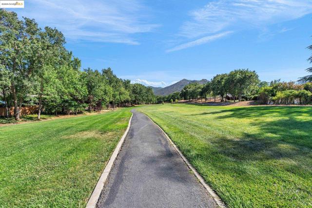 View of asphalt road featuring a mountain view and curbs