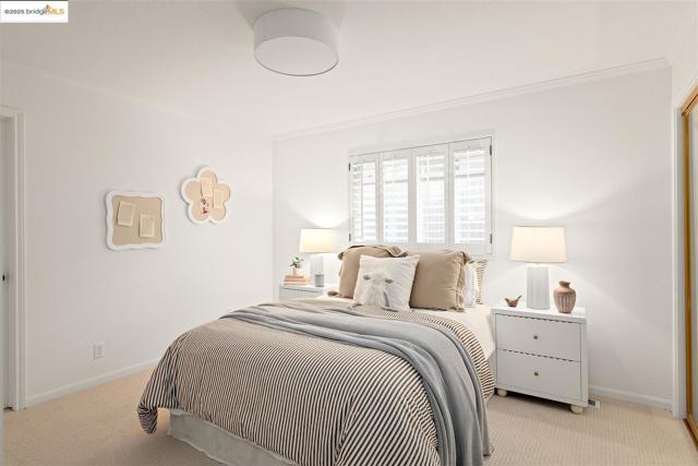 Bedroom with light colored carpet and ornamental molding