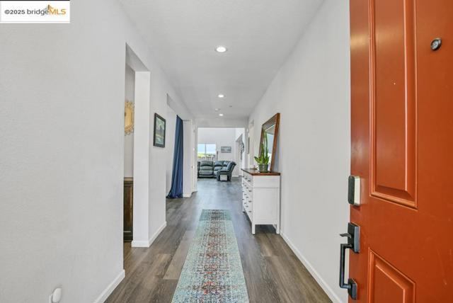 Hallway with dark wood-style floors and recessed lighting