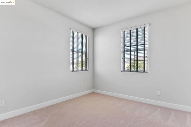 Empty room with light carpet and baseboards