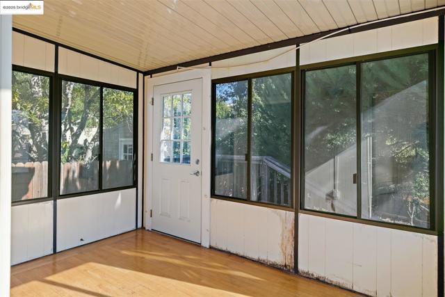Doorway featuring wood finished floors and wood walls