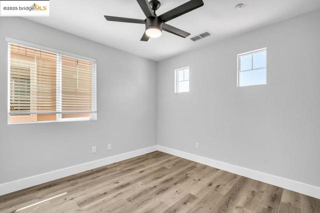 Spare room with wood finished floors and ceiling fan
