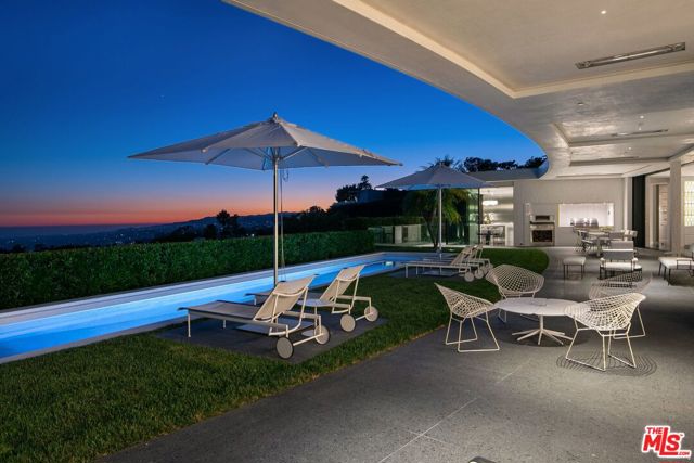 Nestled on one of the most exclusive streets in Trousdale, sits this sophisticated and elegant world-class compound featuring expansive views, total privacy, and specialist finishes. Designed by William Hefner AIA, this new construction home is the epitome of Trousdale living; gates open up a meticulously landscaped motor court, exterior walkway is constructed of split face Thassos. Experience soaring ceilings, walls of glass, and sweeping views of the city towards the Pacific Ocean. Custom and notable finishes include a European kitchen, Bianco nieve marble fireplace, solid marble bar, walls of onyx, and polished plaster, in addition to terrazzo flooring. Generous master wing includes substantial views. Fully automated estate is complete with executive office, media room, theatre space, gym, temperature-controlled wine cellar, and four-car garage. The blend of rich landscaping, natural stones, and a variety of amenities create a true sanctuary.