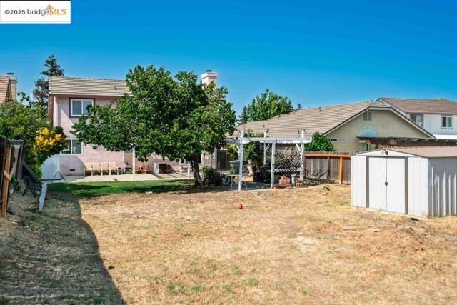 View of yard featuring a shed, a pergola, and a patio