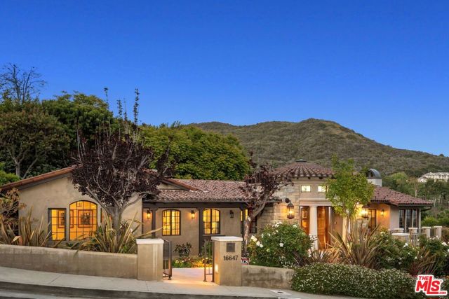 16647 BIENVENEDA Place Pacific Palisades, California A stunning ocean view quality built Mediterranean with strong architectural features located on a coveted cul-de-sac. Remodeled by an architect, it has a light filled rotunda entrance welcoming you to a spacious open floor plan with a high-pitched beamed ceiling living room with fireplace and walls of windows opening to a large dining room with stunning black metal French doors with a dining pavilion to enjoy the twinkling lights of the Santa Monica Bay Ocean view while dining al fresco. The cook's kitchen with copper ceiling and huge center island has a Viking cooktop, stainless steel double ovens, Subzero refrigerator, walk in pantry, custom cabinets, built in home office and wonderful ocean views from the kitchen sink. The attached breakfast room and family room with fireplace and bar open with French doors to the custom tiled patio with built in barbecue and pool in a lushly landscaped yard. There are four ensuite bedrooms plus office all on the one-story floorplan. The primary bedroom opens to the pool and yard with a spa like bath and three additional bedrooms. Downstairs you enter a media room, bonus family room or mother-in-law suite with a 3/4 bath from the oversized garage. This handsome home has striking curb appeal and offers a wonderful floor plan and magnificent views.
