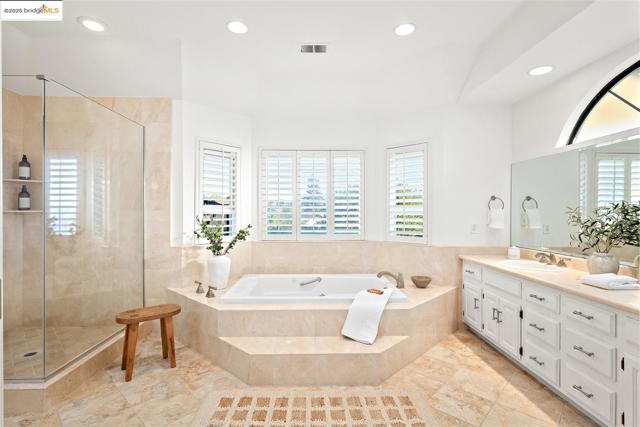 Bathroom with a bath, vanity, a stall shower, plenty of natural light, and recessed lighting