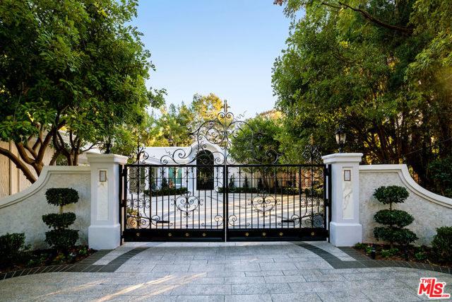 Located on a private enclave off the estate section of Tower Grove in Beverly Hills, this sprawling one story estate has been fully remastered to include a contemporary design combined with its French Regency classic architecture and modern functionality. Set behind gates w/ an oversized motor court, the exterior gives way to a warm interior filled w/ natural woods, imported stone, and intricate details.  High ceilings and a huge living rm offer numerous living and dining options w/ classic french doors providing both an open flow w/ definition of spaces.  Adjacent to the great rm is a chef kitchen w/ an intimate breakfast area, imported marble counters, a large island, and an intimate formal dining rm. Oversized paned windows continue throughout the home and open to the impressive patio, grassy yard, and stylish angular salt water pool with spa and partial city view.  Four main bedrooms, a convertible family rm w/ dry bar and bathroom plus a maids ste are smartly laid out across the 5,745 square foot residence with the primary master suite in particular showcasing a spa-grade bathroom, custom walk-in closet, and the ideal positioning to take in the vantage point across the property. Two car garage w/ electric charger, security cameras and the finest craftsmanship.