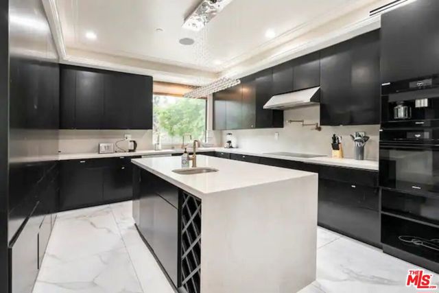 Fully furnished kitchen with high end appliances, wine rack, and island