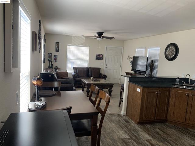 Dining area with dark wood-style floors and ceiling fan