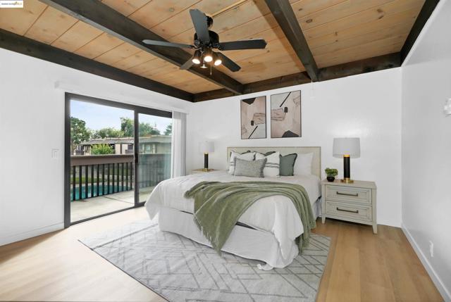 Bedroom featuring a wood ceiling with exposed beams, access to exterior, a ceiling fan, and wood finished floors