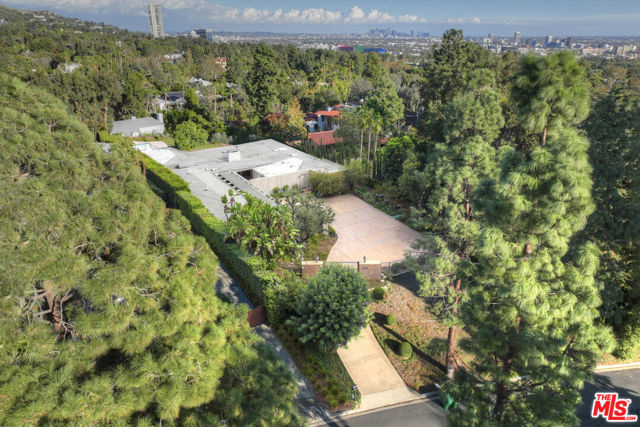 Once in a lifetime opportunity to own an unparalleled property on the prestigious 900 block North Alpine Drive. Enter into a large motor court, and walk through the front doors and be faced with immediate stunning city views. This 34,010 square foot lot features city views and a dramatic backyard, complete with mature trees and lush landscaping. Built in 1953, the 5,458 square foot house boasts high ceilings and great bones. Complete rehab, tear down or development opportunity.